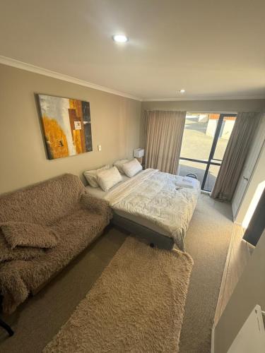 un dormitorio con una cama y un sofá en Casa Miguelle a Private mini house, en Dunedin