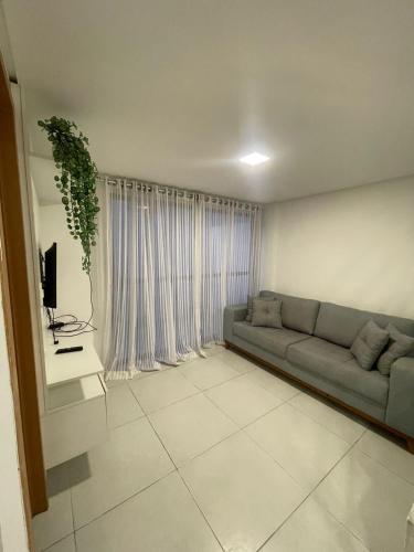 a living room with a couch and a tv at Bangalô Camboinha triplex in Cabedelo