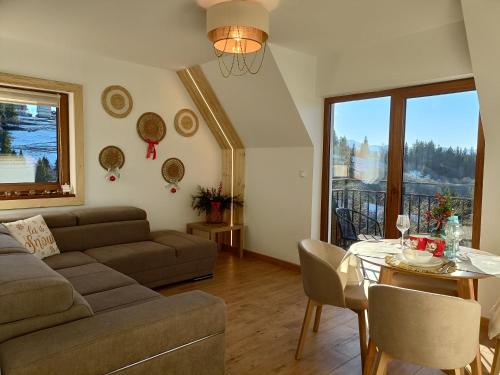 een woonkamer met een bank en een tafel bij Apartament 7niebo in Gliczarów Górny