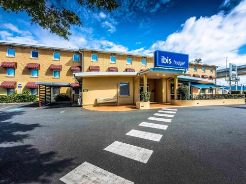 a hotel with aubs mercy sign in a parking lot at ibis Budget Brisbane Airport in Brisbane