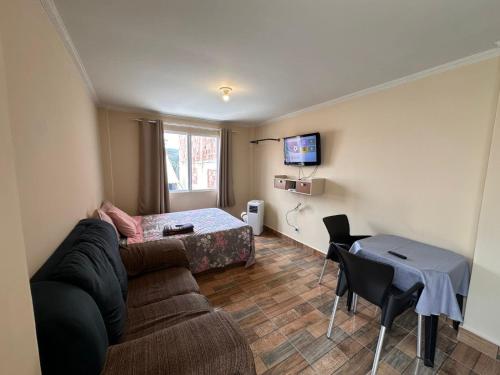 een woonkamer met een bank en een tafel bij Pousada por do sol in Niterói