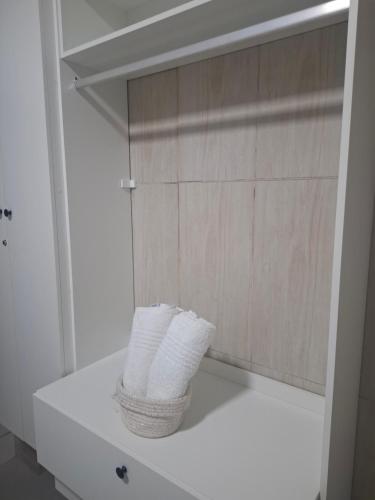 a basket of toilet paper sitting on a shelf in a bathroom at Casa 2 Encanto dos Mares in Itapema