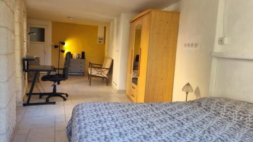 een slaapkamer met een bed en een bureau in een kamer bij La suite d'Ananda in Villefranche-de-Rouergue