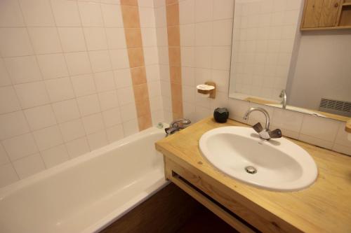a bathroom with a sink and a bath tub at Zenith Appartements VTI in Val Thorens