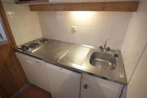 a small kitchen with a stainless steel sink at Zenith Appartements VTI in Val Thorens