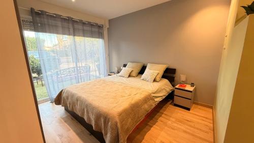 una camera da letto con un letto e una grande finestra di La Chambre du Soleil a Arles