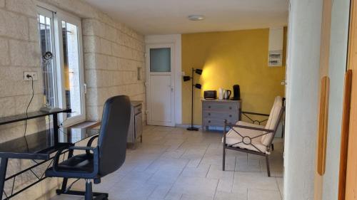 een kamer met 2 stoelen, een bureau en een dressoir bij La suite d'Ananda in Villefranche-de-Rouergue