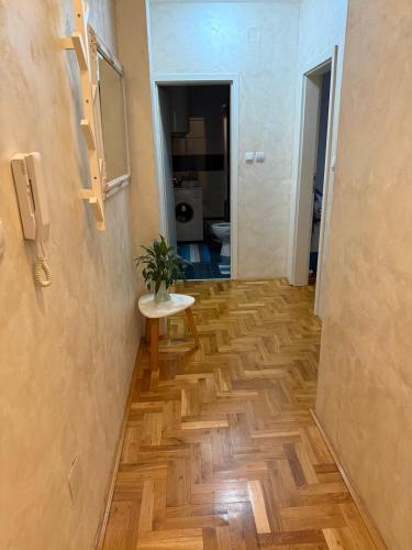 a hallway with a table and a room with a toilet at Apartman Odmor012 in Požarevac