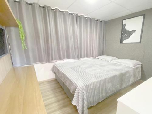 Un dormitorio con una cama frente a una ventana. en Space DR7, en São José dos Pinhais