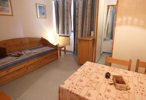 a small bedroom with a bed and a table at Zenith Appartements VTI in Val Thorens