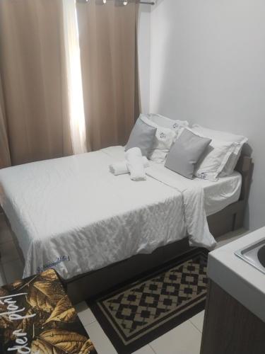 a bed with white sheets and pillows in a room at Nicecondotel in Manila