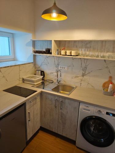 a kitchen with a sink and a washing machine at villa Tema 2 in Ohrid