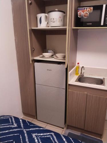 a small kitchen with a sink and a microwave at Nicecondotel in Manila