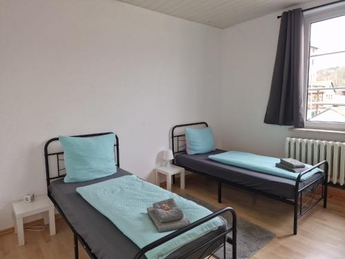 Zimmer - Alte Weinkellerei في Stadtilm: سريرين توأم في غرفة بها نافذة