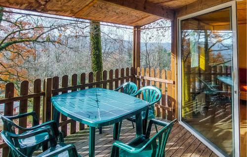 einen blauen Tisch und Stühle auf einer abgeschirmten Veranda in der Unterkunft 2 Bedroom Nice Home In Altillac in Beaulieu-sur-Dordogne