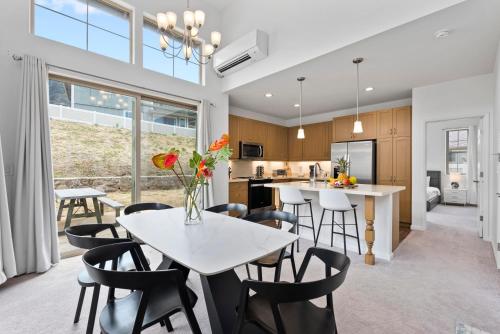 a kitchen and dining room with a white table and chairs at Marbella Lane - Elegant 3BR w Marvelous Views in Waianae
