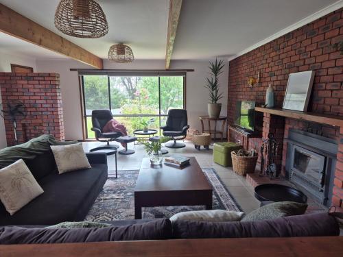 a living room with a couch and a fireplace at Retro Revival - Fondue, Flares & Feeling Groovy in Ocean Grove