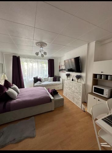 una camera da letto con un letto viola e un divano di Barker House a Londra