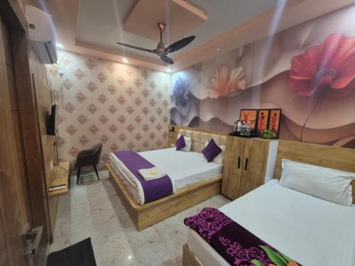 a bedroom with two beds and a flower wall at Hotel Devi Residency Vrindavan - Near Premanand ji Maharaj And Prem Mandir, Banke Bihari ji in Jāmb