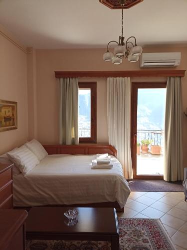 ein Schlafzimmer mit einem Bett und einem großen Fenster in der Unterkunft LOUNA in Metsovo