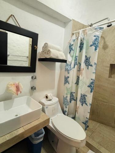 a bathroom with a toilet and a sink and a mirror at Hotel Villa Capricho in Ciudad Madero