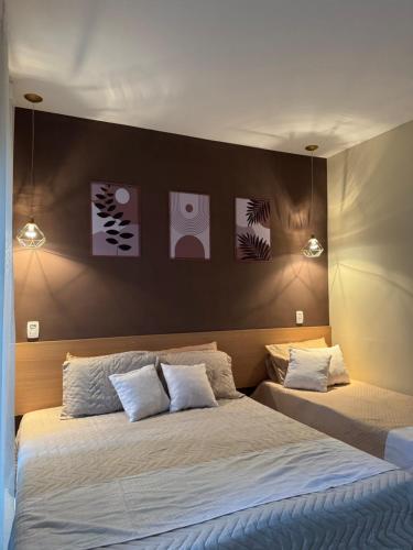 una camera da letto con un letto grande con due cuscini di Apartamento Flat 204 Condomínio Village a Barra do Piraí