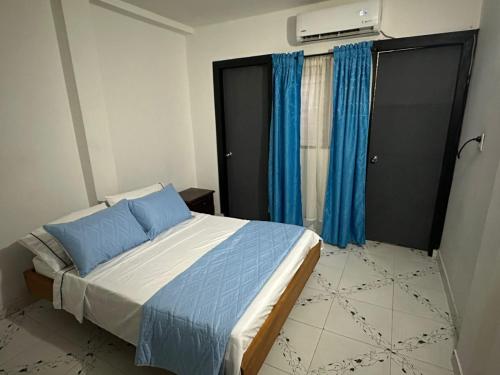 莱蒂西亚Casa Vacanza Apartamento 1的一间卧室配有一张带蓝色床单和蓝色窗帘的床。