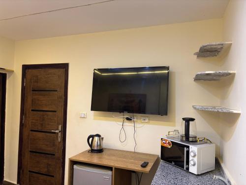 ein Zimmer mit einem Flachbildfernseher an der Wand in der Unterkunft 4 Pyramids INN in Kairo