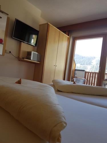 a hotel room with two beds and a large window at Hotel Garni Alpendiamant in Fiss