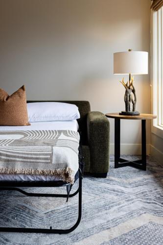 a bedroom with a bed and a table with a lamp at Misty Mountain- Premium 2 Bedroom Mountain View in Canmore