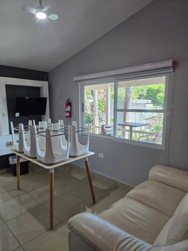 Una sala de estar con un sofá y una mesa con sillas. en Always Summer Inn, en Culebra