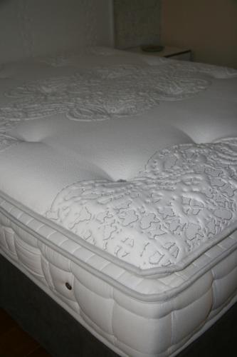 a close up of a white mattress on a bed at Les Suites Champenoises in Reims