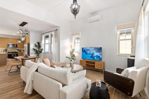 ein Wohnzimmer mit weißen Möbeln und einem Fernseher in der Unterkunft Marbella Lane - 2 master suites MTOcean Views in Makaha Valley