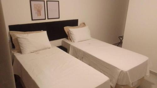 Ένα ή περισσότερα κρεβάτια σε δωμάτιο στο Hotel Rosa da Ilha Guaruja - Perto do Mar com piscina