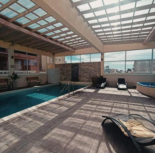 a large indoor swimming pool with a large glass ceiling at Apart Sorrento in Santa Teresita