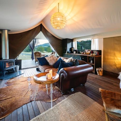 a living room with a couch and a table at Kanimbia Luxury Glamping in Obi Obi