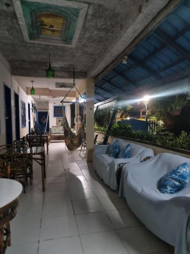 a room with three beds and a hammock in it at Pousada Solstício De Verão in Trindade