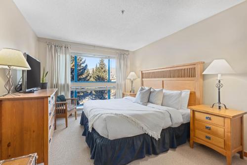 Un dormitorio con una cama grande y una ventana. en 3BR in Greystone Lodge, Ski In, Ski Out, Pool and Hot Tub, Epic Location, en Whistler
