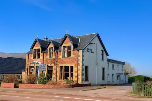 a building with a black roof on a street at Ben View Guesthouse in Fort William