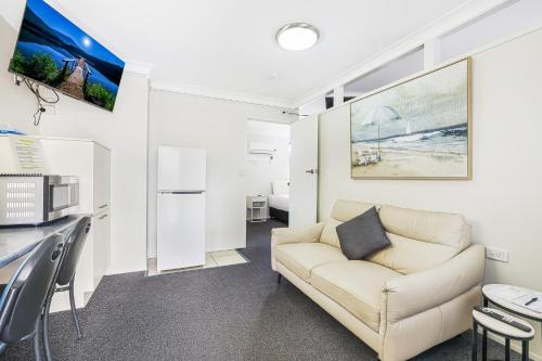 a living room with a couch and a table at Acacia Motor Inn in Bundaberg