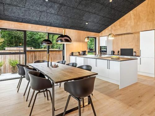 a kitchen and dining room with a wooden table and chairs at 5 star holiday home in Skals in Skals