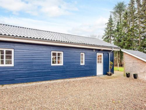 a blue house with a white door and a yard at 4 person holiday home in Ansager in Ansager