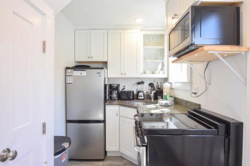 a kitchen with a refrigerator and a sink at Condo w Beach Access & Water Views in Provincetown