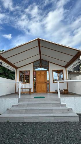 ein Gebäude mit einem großen Dach mit einer Holztür in der Unterkunft Eco cabañas montana in El Cerrito