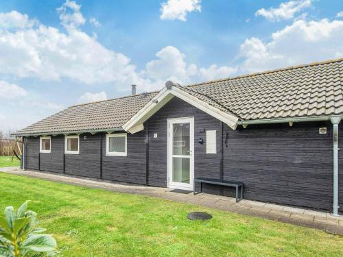 a black house with a bench in front of it at 5 star holiday home in Ansager in Ansager