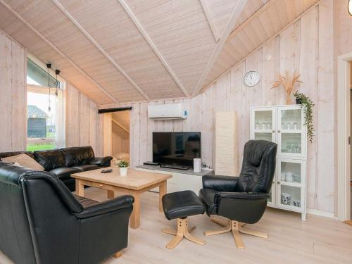 a living room with black leather furniture and a tv at 5 star holiday home in Ansager in Ansager