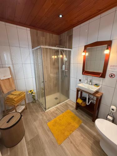 a bathroom with a shower and a sink at Refúgio das Pedreiras in Praia da Vitória