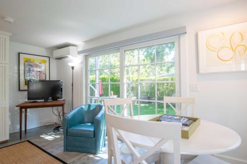 a living room with a table and chairs and a tv at East End Condo w Beach Access in Provincetown