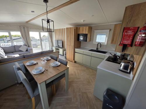 een keuken en een woonkamer met een tafel in een caravan bij Luxury 3 bed sleeps 8 caravan with sea view in Exmouth