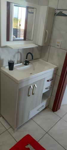een keuken met een wastafel en een spiegel bij Vista mar 1 in Imbituba
